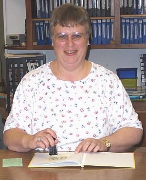 Photo of librarian checking out a book.